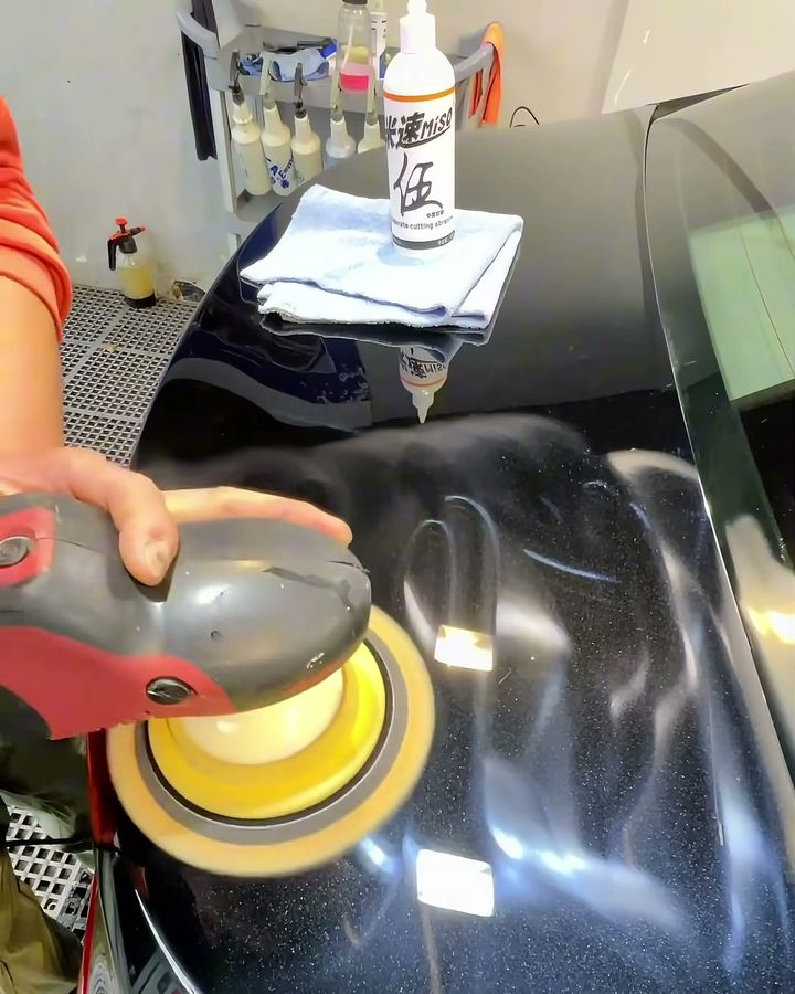 A bottle of MISO No.5 sits on a black car roof, with a rotary polisher (RO) running next to it.